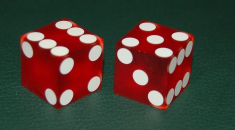 Two craps dice on a green background. From Wikimedia Commons.