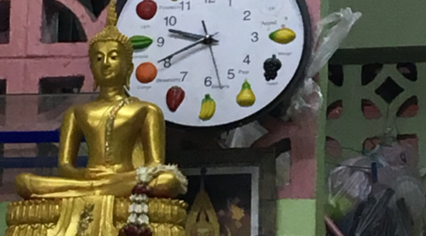 A clock with fruits where numbers are normally seen.